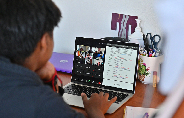 A student participating in an online class, while working on the course.